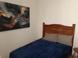 een slaapkamer met een bed met een schilderij aan de muur bij La casa de Luna in Puerto Vallarta