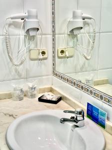bagno con lavandino e specchio di Hotel La Rivera a Arenas de Cabrales