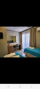 a hotel room with two beds and a desk at Başar hotel in Erdemli