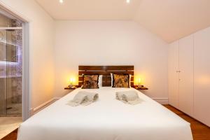 - une chambre avec un grand lit blanc et deux lampes dans l'établissement Classy Belas Artes, à Porto