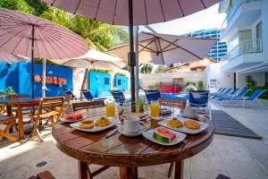 un tavolo con cibo e bevande su un patio con ombrelloni di Hotel Santorini Resort a Santa Marta Altre 37 foto