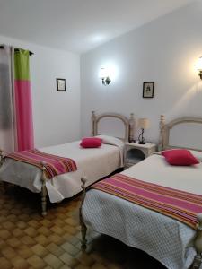 um quarto com 2 camas e almofadas vermelhas em Villa Cristina e Ricardo em Carvoeiro