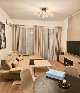 een woonkamer met een bank en een tv bij Belgrade Waterfront Zvoncica Apartament in Belgrado