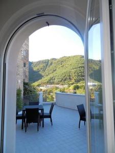 a balcony with a table and chairs and a view at Il Pescemagra HostelAmeglia in Ameglia