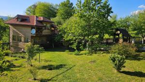 a house with a yard with trees and a fence at Vacation Home Gaj in Visoko