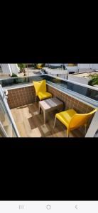 two yellow chairs and a table next to a swimming pool at Başar hotel in Erdemli