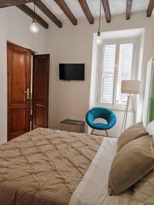 una camera con un grande letto e una sedia blu di Jolie Maison au coeur de Parma avec Parking privé inclusif a Parma