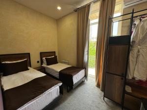 a hotel room with two beds and a window at Liberta Hotel Baku in Baku