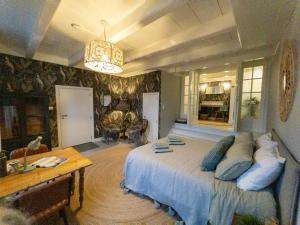 a bedroom with a large bed and a table at Bed & Breakfast [H]eerlijk! in De Kwakel