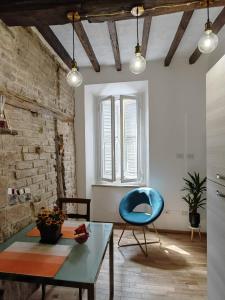 uma sala de estar com uma mesa e uma cadeira azul em Jolie Maison au coeur de Parma Parking privé gratuit em Parma
