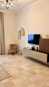 uma sala de estar com uma televisão de ecrã plano e uma cadeira em Appartamento moderno Freidour, metro Rivoli em Turim