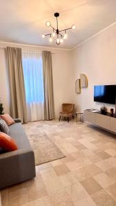 uma sala de estar com um sofá e uma televisão de ecrã plano em Appartamento moderno Freidour, metro Rivoli em Turim