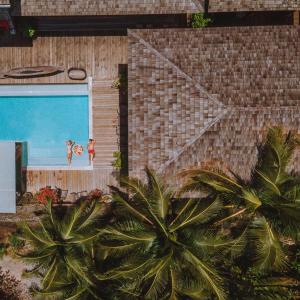 two people standing on the side of a building with a pool at House Of Passion Amphawa in Amphawa