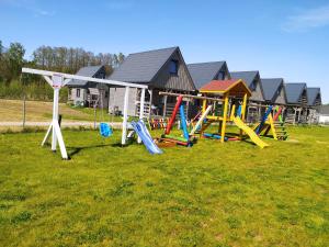a playground with colorful play equipment in a field at Domki Martes Wicie in Wicie