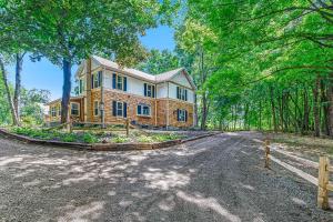 a large house on a road in the woods at Thorndale - Modern Smart Home on 20 Pastoral Acres with a Private Heated Pool & Hot Tub in Fennville