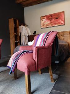 Finca La Valletana في Vista Flores: غرفة نوم مع كرسي عليه بطانية