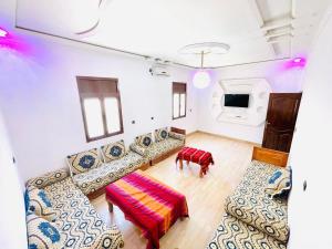 a living room with a couch and a table at Merzouga Lodge in Merzouga
