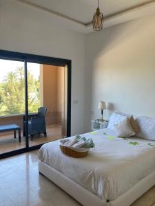 Schlafzimmer mit einem großen Bett und Blick auf eine Terrasse in der Unterkunft New villa in Marrakech palmeraie in Marrakesch