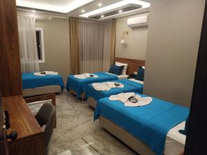 a hotel room with three beds in a room at Başar hotel in Erdemli