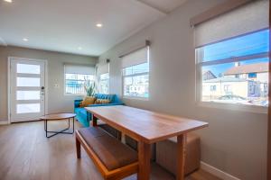 a living room with a wooden table and a blue couch at Ocean Beach Retreat, 3BR Newly Remodeled, Steps to Beach and Boardwalk in San Diego