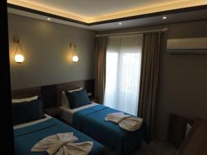 a bedroom with two beds with towels on them at Başar hotel in Erdemli