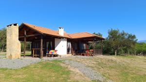 uma pequena casa branca com um telhado castanho em El Cardon - Casa de Campo em Coronel Moldes