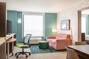 Home2 Suites By Hilton Cheyenne في شايان: غرفة في الفندق بها كرسي و أريكة