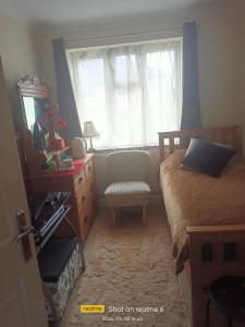 sypialnia z łóżkiem, komodą i oknem w obiekcie Goldy's place in E17 Room2 w Londynie