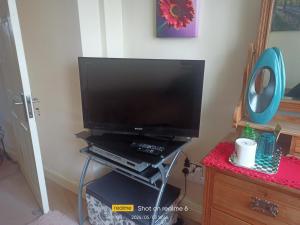 telewizor z płaskim ekranem siedzący na stojaku w pokoju w obiekcie Goldy's place in E17 Room2 w Londynie