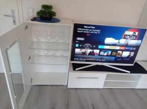 un meuble blanc avec une télévision et des verres à vin dans l'établissement Work and Stay Sundern-Allendorf Modernisierte Unterkunft mit 5 Betten plus Schlafcouch mit Balkon, à Allendorf