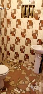 a bathroom with a toilet and a sink at CHEZ ALFA in Jugu