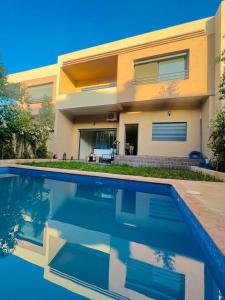 una casa con una piscina di fronte di New villa in Marrakech palmeraie a Marrakech