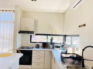 a kitchen with white cabinets and a sink at DEE-LOFT 53 in Windhoek