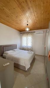 1 dormitorio con 1 cama grande y techo de madera en Lugina e Komanit en Koman