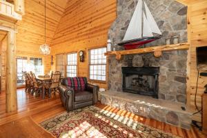 un salon avec une cheminée en pierre et une table dans l'établissement Our Get Aweigh - Cabin Retreat - private hot tub - community pool - Goshorn Lake Access, à Saugatuck