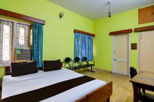 um quarto com uma cama num quarto com paredes verdes em OYO Ramya Guest House em Calcutá