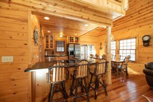 une cuisine et une salle à manger avec un bar dans une cabane en rondins dans l'établissement Our Get Aweigh - Cabin Retreat - private hot tub - community pool - Goshorn Lake Access, à Saugatuck