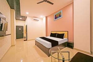a bedroom with a bed and a glass table at OYO Hotel Agrawal Inn in Bhopal