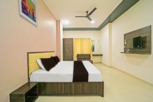 a bedroom with a bed and a ceiling fan at OYO Hotel Agrawal Inn in Bhopal