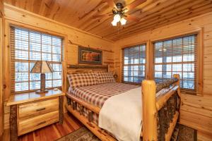 une chambre avec un lit dans une cabane en rondins dans l'établissement Our Get Aweigh - Cabin Retreat - private hot tub - community pool - Goshorn Lake Access, à Saugatuck