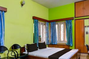 um quarto com uma cama com paredes azuis e verdes em OYO Ramya Guest House em Calcutá