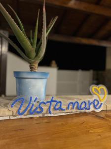 a plant in a blue vase sitting on a table at Vista mare Fiumicino in Fiumicino