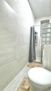 a white bathroom with a toilet and a shower at Your Room in Sarajevo