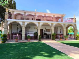 une grande maison avec une pelouse devant elle dans l'établissement Esmeraldas Vivienda Rural, à Villacarrillo