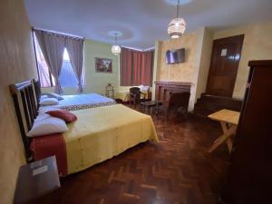a bedroom with a large bed and a living room at HOTEL IXBALANQUE in La Aurora