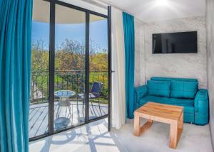 a living room with a blue couch and a balcony at Villaggio Mirzaani Resort in Sighnaghi