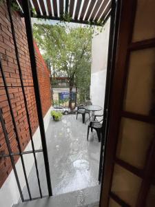 una puerta abierta a un patio con mesa y sillas en Arguibel 2833 en Buenos Aires