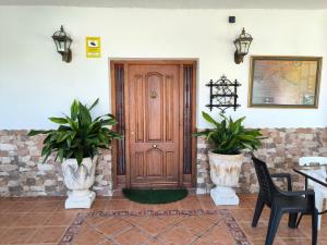 une porte en bois dans une pièce avec deux plantes en vases dans l'établissement Esmeraldas Vivienda Rural, à Villacarrillo