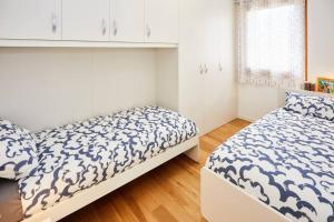 a bedroom with two beds and a window at Lux Apartment Aviano Centro AC Parking in Aviano