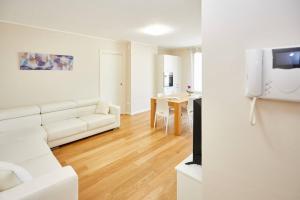 a living room with a white couch and a table at Lux Apartment Aviano Centro AC Parking in Aviano